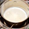 Đun nóng sữa lên 85 độ C cho sữa hơi bắt đầu sủi bọt (không đun sôi). Nên sử dụng nồi đế dày hoặc đun cách thủy để tránh làm cháy sữa. Sau đó, để nguội sữa xuống 43 độ C, dùng khăn lạnh quấn quanh nồi để hạ nhiệt được nhanh hơn. Nếu cho vào tủ lạnh hoặc để nguội ở nhiệt độ phòng, hãy khuấy sữa thường xuyên để tránh bị đóng váng.