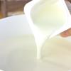 Để hỗn hợp sữa nguội bớt khoảng 40 độ C rồi mới thêm 100gr sữa chua cái đã mịn vào hủ. Khuấy nhẹ tay cho hỗn hợp hòa quyện. 