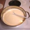 Để sữa vừa đun nguội còn hơi âm ấm thì cho sữa chua làm men vào. Khuấy đều từ từ.