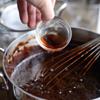 Chế siro bắp vào nồi cacao đường, khuấy hỗn hợp hòa tan đều vào nhau. Thêm 1 muỗng canh tinh chất vani và 1/4 muỗng cà phê muối vào, khuấy liên tục cho đến khi hỗn hợp sôi thì tắt bếp.