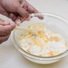 Cho trứng gà vào thau đã để sẵn đá viên, sau đó cho bột vào cùng và dùng đũa khuấy đều tay và nhanh.Add melted egg and ice to the measuring cup and put it in the ball.  Add more flour and mix quickly with chopsticks. Do not have to mix too much.