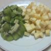 Kiwi, táo rửa sạch, gọt vỏ, cắt hạt lựu, cho ra đĩa. Sau đó, cho kiwi, táo ra từng hộp nhựa nhỏ.