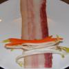 Thịt ba chỉ trải dài ra đĩa, xếp các nguyên liệu giá đỗ và cà rốt đã thái sợi lên trên, cuộn tròn lại.