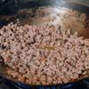 Làm nóng chảo chống dính, cho ít dầu ăn vào rồi thêm thịt heo băm vào vừa nấu vừa đảo cho thịt rút nước, vừa chín tới.