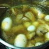Tiếp theo, cho 250ml nước dừa, trứng vịt, trứng cút vào, nấu khoảng 10 phút. Nêm gia vị 1 muỗng canh nước mắm, 1 muỗng canh nước màu, 1 muỗng cà phê hạt nêm cho vừa ăn.