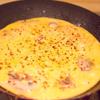 Đến khi thấy bề mặt trứng hơi đông lại thì rắc ít ớt bột lên trên. Đậy nắp và để lửa liu riu, đến khi trứng chin hoàn toàn thì tắt bếp.