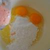 Đập trứng ra tô, thêm bột mì và hỗn hợp nước cà chua vừa xay ở trên vào chén. Sau đó, thêm hạt nêm và nước tương cho vừa ăn rồi khuấy đều.