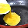 Đun nóng 2 muỗng canh dầu ăn rồi cho trứng vào, dàn mỏng đều mặt trong chảo.