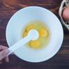 Tiếp theo đập 4 quả trứng gà vào tô, nêm 1 muỗng cà phê muối, 1 muỗng cà phê rượu sake. Việc cho thêm rượu vào sẽ làm giảm vị tanh của trứng và món trứng khi chiên sẽ ngon hơn.