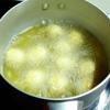 Đun nóng dầu ăn trong nồi nhỏ, cho trứng đã áo bột vào chiên chín vàng đều thì vớt rá để ráo dầu.