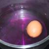 Dùng muỗng gõ nhẹ lên vỏ trứng để tạo những đường nứt nhỏ. Sau đó cho trứng vào nước màu bắp cải tím vừa đun, luộc thêm khoảng 15-20 phút rồi vớt trứng ra.