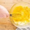 Phô mai cho ra tô lớn, lần lượt đập trứng gà vào, thêm chút tiêu và muối rồi đánh tan. Sau đó đổ hỗn hợp hành tây vào, trộn thật đều và đổ ra luôn nướng. Cho trứng vào lò nướng tầm 30 phút đến khi thấy trứng có màu vàng nâu thì lấy là có thể ăn được.