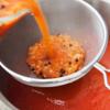 Lọc hỗn hợp cà chua ở bước 4 qua rây, cho vào nồi nước cà chua, trộn đều.
