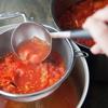 Lọc 1/2 cà chua qua rây, dùng muỗng ép nhẹ để cà chua ra hết nước, bỏ bã.