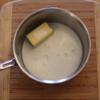 Trong khi luộc khoai, cho 5g bơ và 100ml sữa tươi vào chảo và chờ cho bơ tan tự nhiên. 