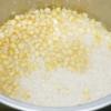 Vo sạch gạo nếp rồi đem nấu chín cùng hạt bắp bằng nồi cơm điện.