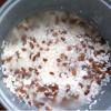 Cho gạo nếp đã ngâm vào nồi cơm điện, cho phần đậu đã luộc lên và trộn đều. Nấu một nồi nước sôi và đổ nước sôi vào phần gạo nếp đã trộn cùng đậu. Cho nước xâm xấp mặt nếp (0.3 - 0.5 cm). Bật nút nấu chín như nấu cơm.