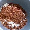 Cho gạo nếp đã ngâm vào nồi cơm điện, cho phần đậu đã luộc lên và trộn đều. Nấu một nồi nước sôi và đổ nước sôi vào phần gạo nếp đã trộn cùng đậu. Cho nước xâm xấp mặt nếp (0.3 - 0.5 cm). Bật nút nấu chín như nấu cơm.