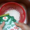 Gạo nếp cho ra rổ, rửa sạch và ngâm trong nước lạnh 15 phút. Việc ngâm gạo nếp sẽ giúp hạt nếp không bị bể trong quá trình nấu xôi, hạt nếp căng bóng nhìn đẹp mắt.