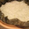 Ngâm gạo nếp trong ít nhất 2 giờ. Để ráo nước, sau đó hấp trong một nồi hơi khoảng 20 phút (gần chín). Ướp gà với muối, 1/2 muỗng canh nước tương, tiêu và 1/2 muỗng canh dầu hào.