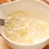 Cho 125g bột mì vào tô, sau đó đập 2 quả trứng vào tô và trộn đều hỗn hợp. Trong khi đánh đều trứng, bạn cho thêm từ từ sữa vào và tiếp tục đánh đều cho tới khi được hỗn hợp bột đặc, mịn và không bị vón cục.